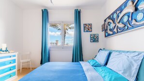 Un dormitorio con cama, cómoda y ventana con cortinas.