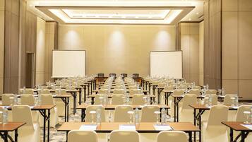 A conference room with rows of tables, chairs, and water bottles.