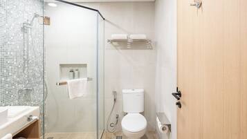 Un baño moderno con ducha envuelta en vidrio, un inodoro y un lavabo.