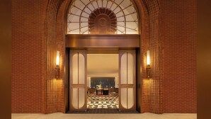 A grand entrance with a brick facade, a large arched window, and a checkered floor pattern. - voco Xishuangbanna Gaozhuang by IHG (Xishuangbanna Dai)