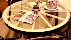 A round glass table with a central decorative item, surrounded by chairs.