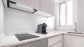 Een moderne keuken met een ingebouwde koffiezetapparaat, een raam en een spoelbak.