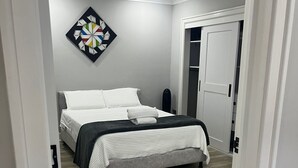 Un dormitorio con una cama, una obra de arte en la pared y una puerta que da a un armario.