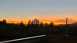 On peut admirer un magnifique coucher de soleil sur un paysage boisé depuis un balcon doté d’un plancher en verre.