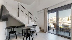 Eine moderne Wohnung mit Essbereich, einer Treppe und einem großen Balkon mit Blick auf die Stadt.