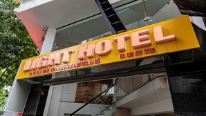 Une enseigne d’hôtel portant le nom « LIGHT HOTEL » et un numéro de téléphone.