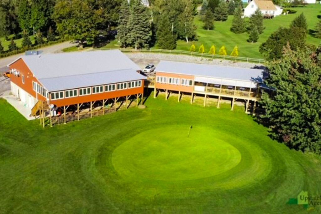 A large building with a flat roof and a circular lawn area.