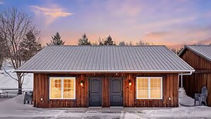 A wooden building with a metal roof, two doors, and windows. - Golf, Outdoor Bar, Restaurant - The Forest Haven (Tully)