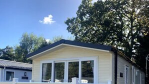 A mobile home with a white deck and a covered porch.