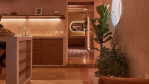 Un interior moderno con cocina, comedor y zona de estar con una planta.