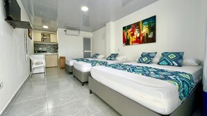 Una habitación de hotel moderna con dos camas, kitchenette y zona de comedor.