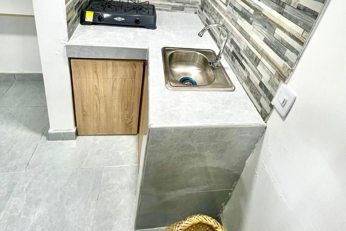 A compact kitchen with a gas stove, a sink, and wooden cabinets.