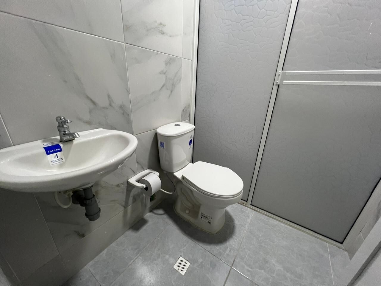 A bathroom with a sink, toilet, and shower area.