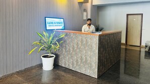 A reception desk with a sign for LUXE 8 STAYZ SERVICE APARTMENTS. - Luxe 8 Stayz  (Gurugram)