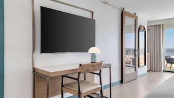 A modern hotel room with a desk, chair, and a large mirror.