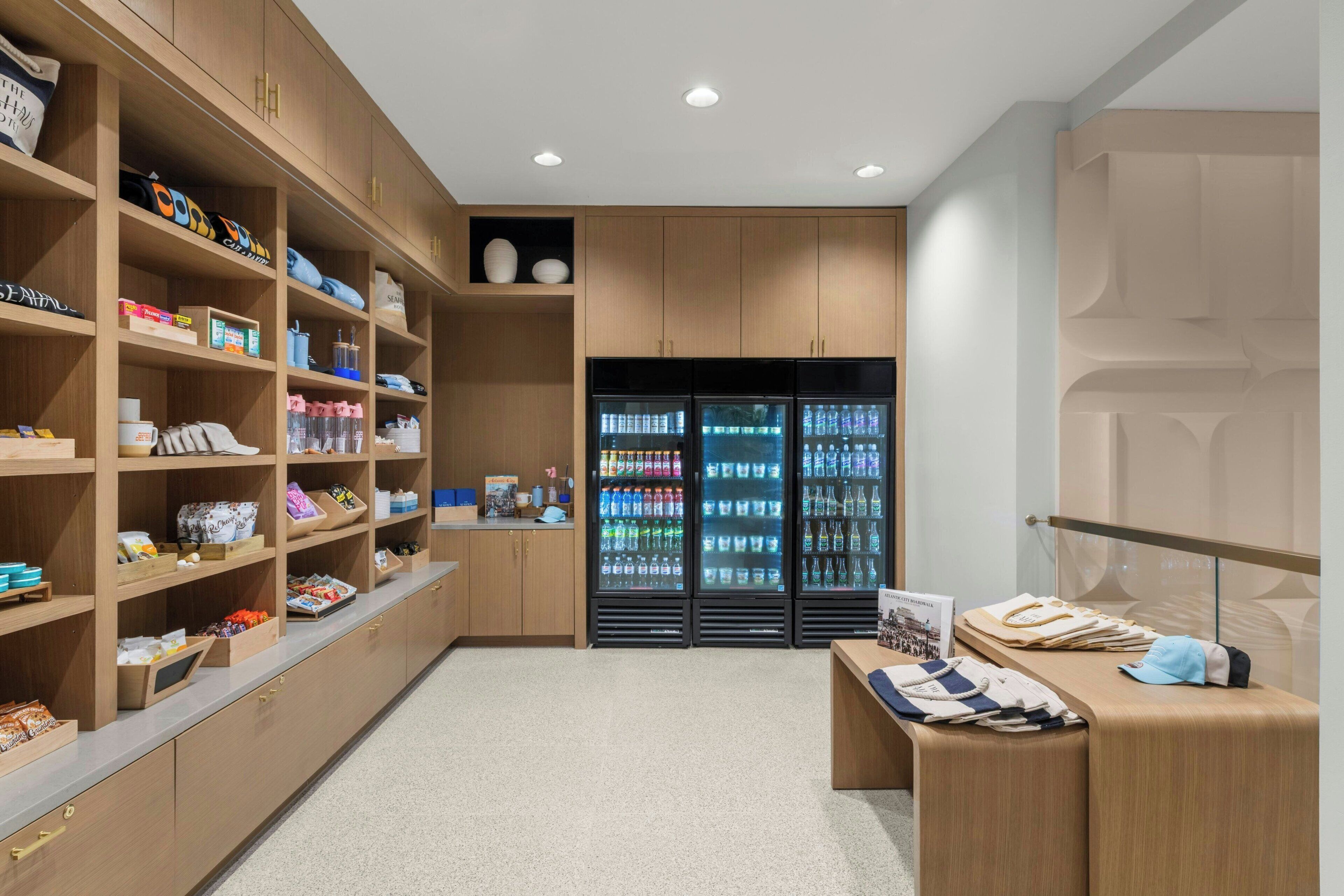 A modern retail space with wooden shelving, a display counter, and refrigerated beverage cases.