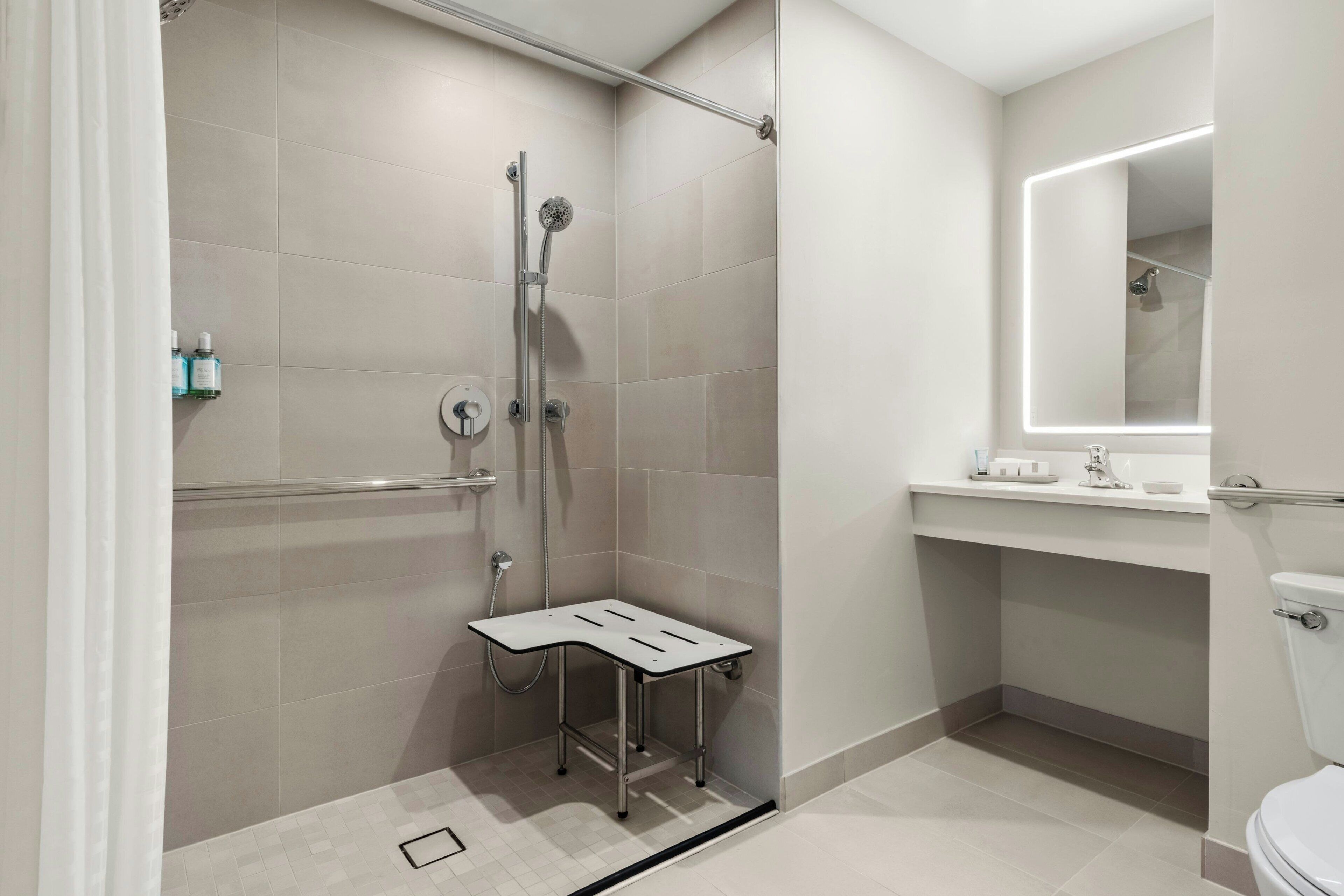 A modern bathroom with a shower, toilet, and vanity.