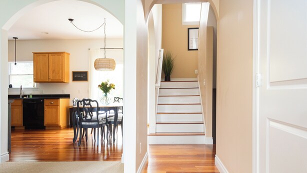A spacious kitchen with wooden cabinets, a dining area with chairs, and a staircase leading to another level. - Abe's Hideaway - Arcade, Hot Tub, Home Theater - Quiet upscale neighborhood (Springfield)