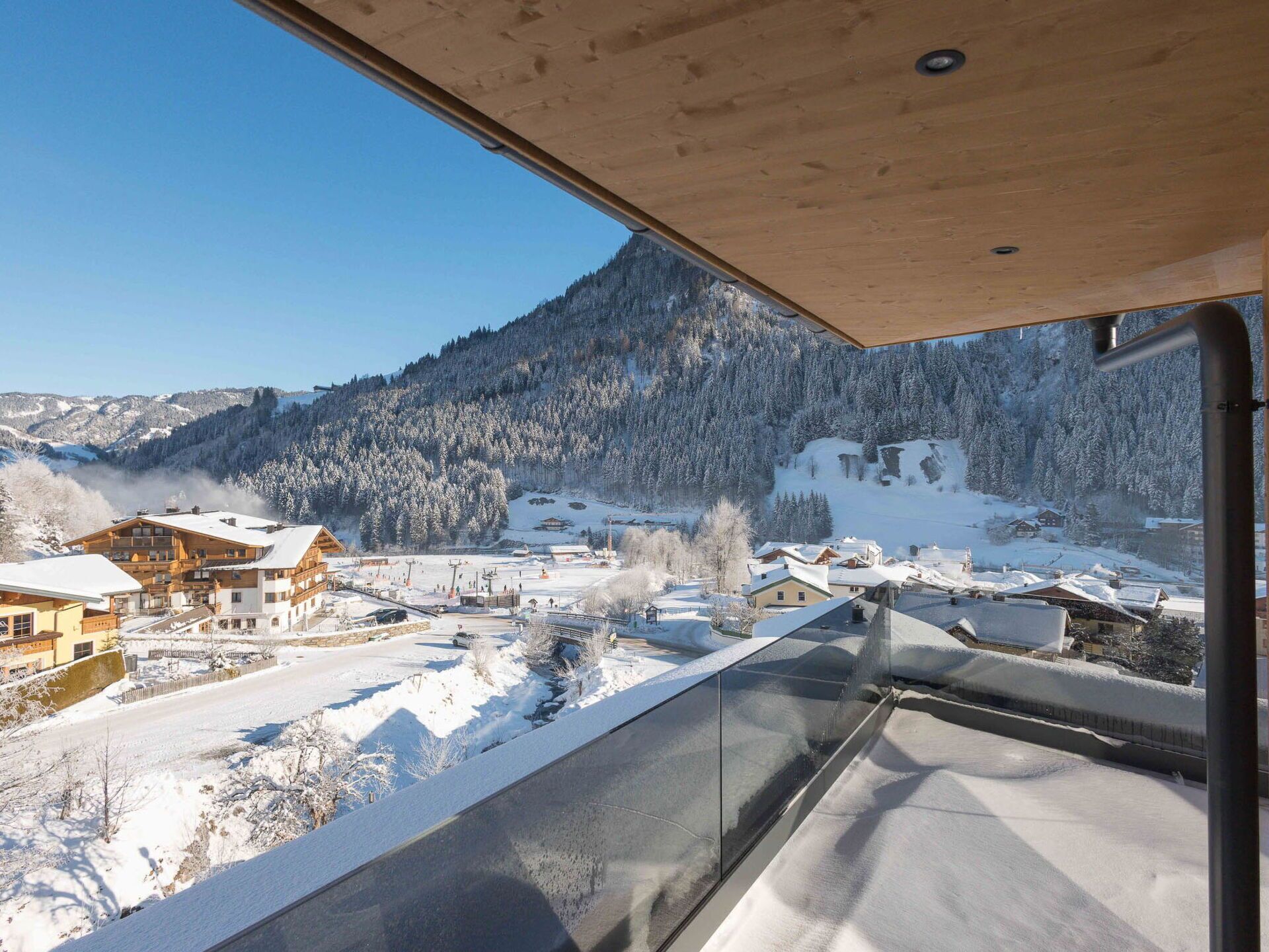 A modern building with a balcony overlooking a snowy mountain landscape.