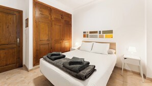 A hotel room with a large bed, wooden wardrobe, and a nightstand with a lamp. - Home2Book La Casita del Puerto, Playa Blanca (Playa Blanca)