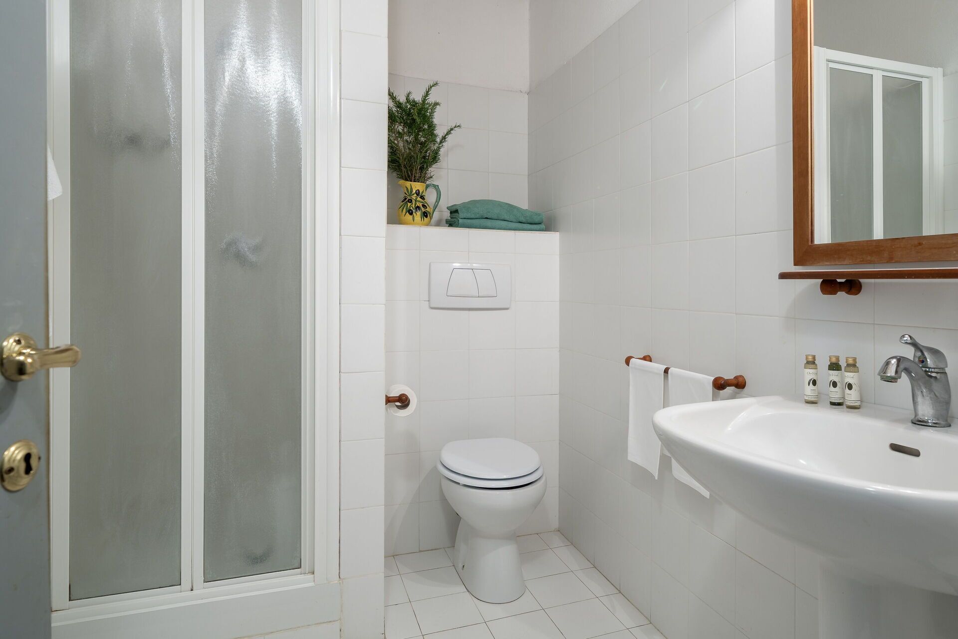 A bathroom with a toilet, sink, and shower.