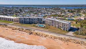 A coastal hotel with multiple floors, a swimming pool, and a beachfront view. -  Spacious Ormond Oceanfront  3 bedroom Condo (Ormond Beach)