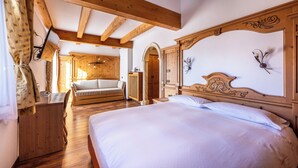 Une chambre avec un grand lit, un bureau en bois et une armoire en bois.