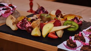 Une variété de fruits et de pâtisseries sont disposés sur une table.