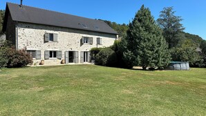 A stone house with a sloped roof, multiple windows, and a large tree in the front yard. - House to rent for summer holiday weekends for 8 -9-10- 11 - 12 - 13 persons (Compolibat)