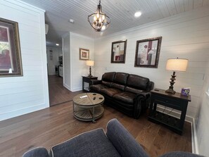 A living room with a brown leather sofa, a coffee table, and a lamp.