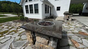 A house with a stone patio and a fire pit.