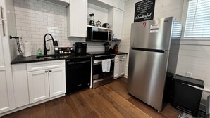 A modern kitchen with white cabinets, a stainless steel refrigerator, a microwave, and a coffee maker. - Charming Lodge 1.5 to Dollywood (Sevier County)