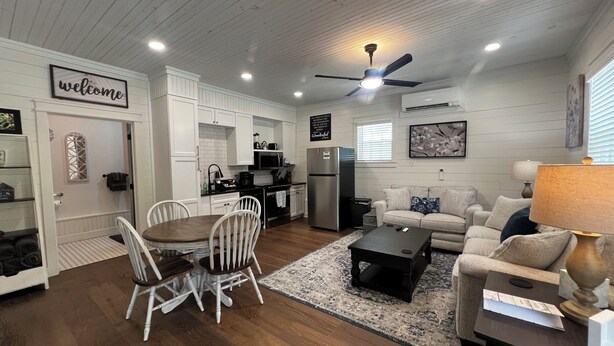 A spacious living room with a dining area, a kitchen, and a ceiling fan. - Charming Lodge 1.5 to Dollywood (Sevier County)