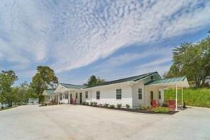 A two-story building with a covered porch and a driveway. - Charming Lodge 1.5 to Dollywood (Sevier County)