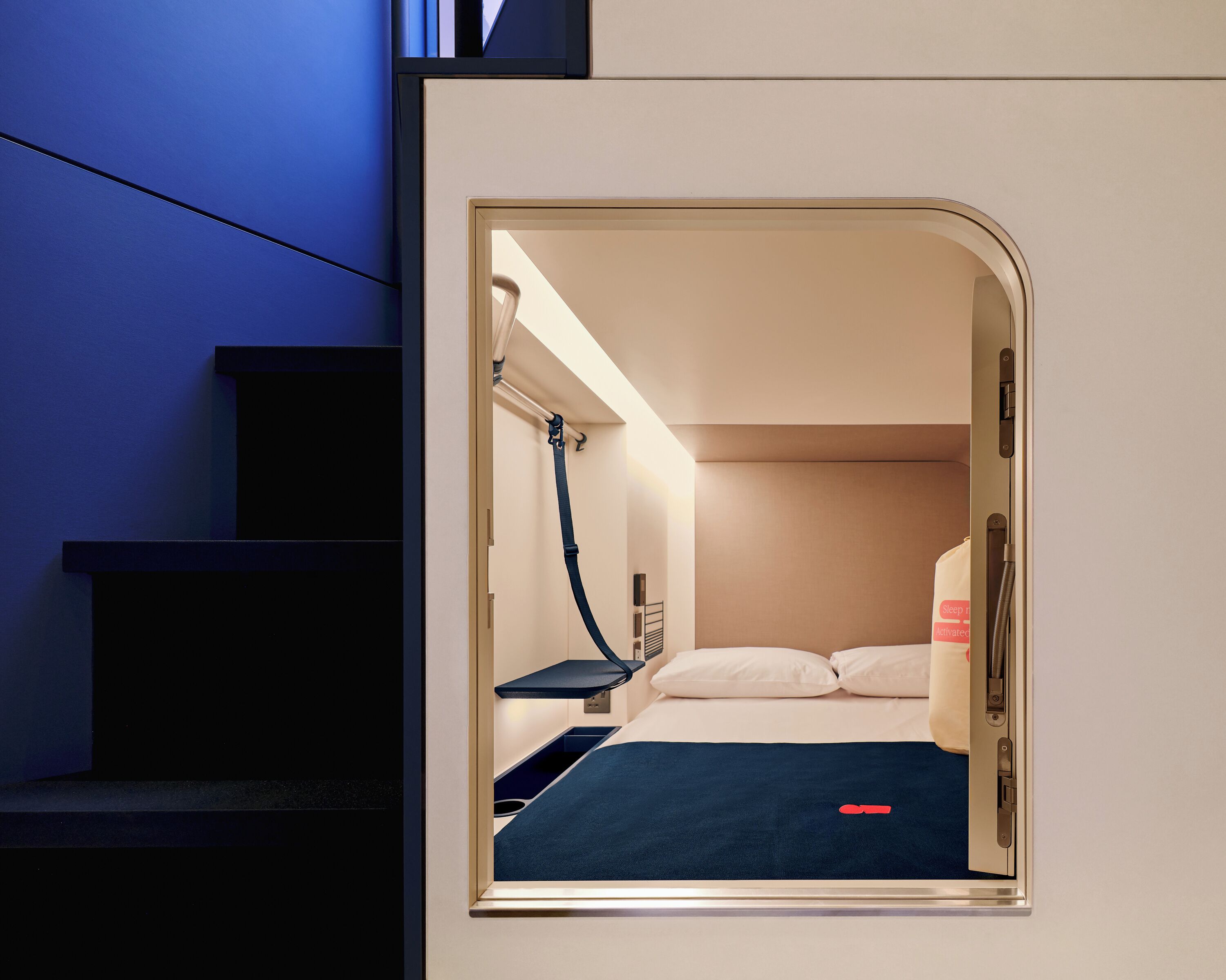 Una habitación de hotel pequeña con cama, un escritorio y zona de ducha.