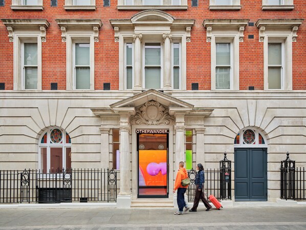 A building facade with a prominent entrance, large windows, and a decorative archway. - Otherwander Soho Pod Hotel (ADULTS ONLY) (London)