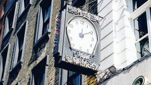Un bâtiment orné d’une horloge et d’une enseigne sur laquelle on peut lire « Bar Italia ».