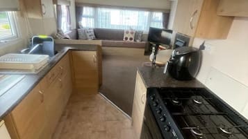 A compact kitchen with a stove, sink, and cabinets.
