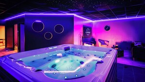 Une salle de spa équipée d’un jacuzzi, d’une horloge et d’une pancarte sur laquelle on peut lire « LAPARTHESIS ».