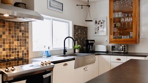 Uma cozinha moderna com uma ilha grande, eletrodomésticos de aço inoxidável e uma cafeteira.