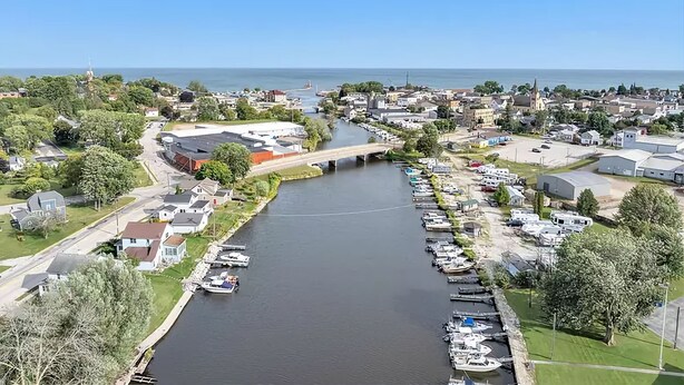 An aerial view of a riverside town with a bridge, boats, and residential buildings. - Upper River House Waterfront Getaway on Ahnapee River with Dock Boat Slip Wifi (Algoma)