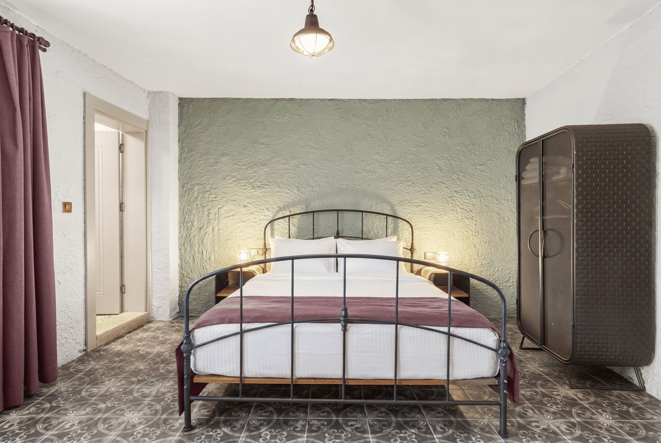 A room with a bed, a wardrobe, and a door.