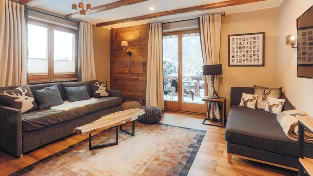 Ein gemütliches Wohnzimmer mit einer Couch, einer Bank und einem Kamin.