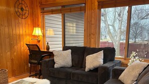 A cozy living room with a dark grey sofa set, a small table, and a lamp. - 4-bedroom home in Eagen,family friendly, centrally located with fenced backyard (Eagan)