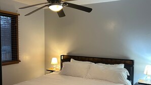 A bedroom with a bed, a ceiling fan, a nightstand with a lamp, and a window with blinds. - 4-bedroom home in Eagen,family friendly, centrally located with fenced backyard (Eagan)
