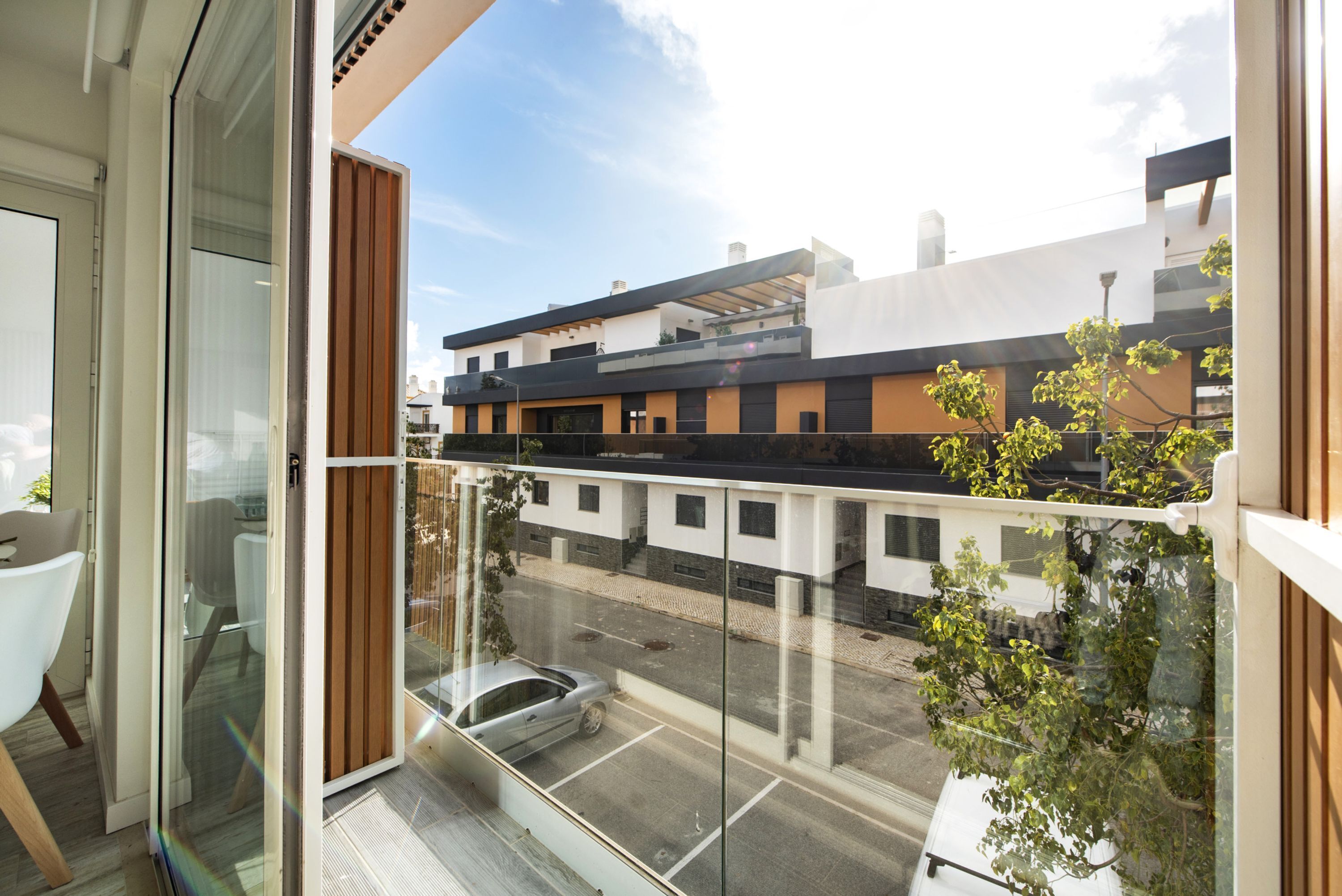 Un apartamento moderno con balcón, ventanas amplias y vista a la calle.
