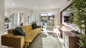 En moderne stue med sofa, sofabord og et skriveområde.