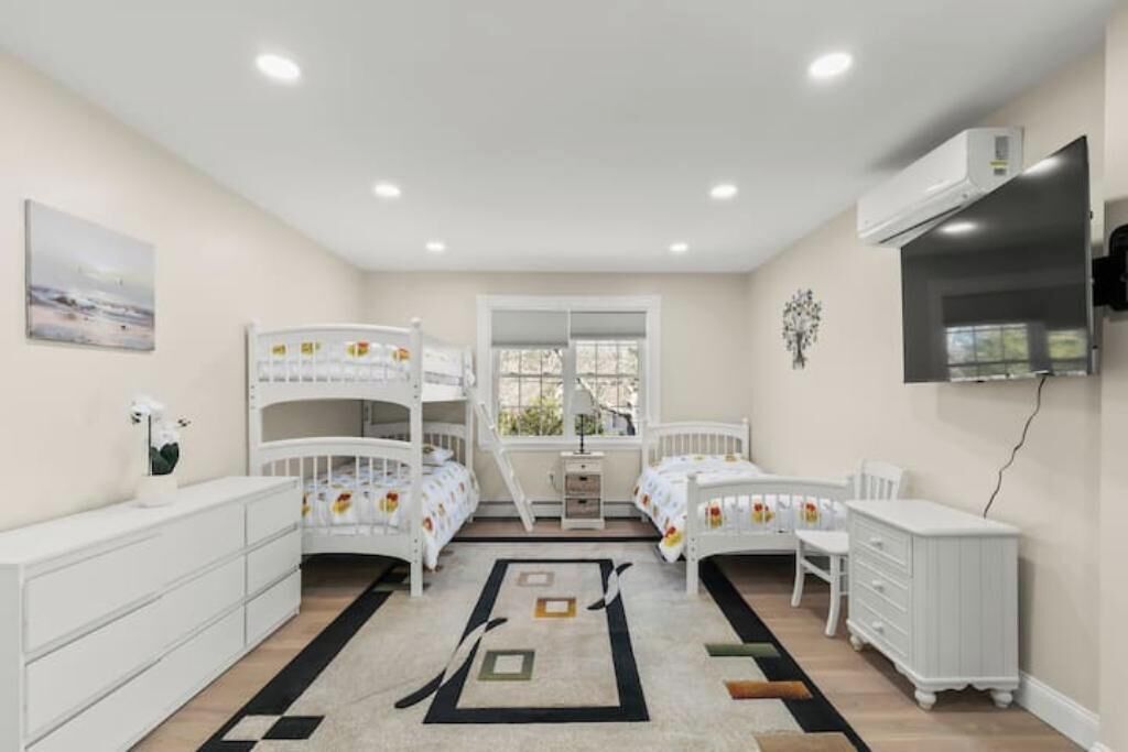 A child’s bedroom with bunk beds, a desk, and a TV.