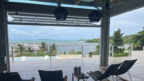 Un balcone con due poltrone a dondolo, un tavolino e vista sul mare e sul porto.