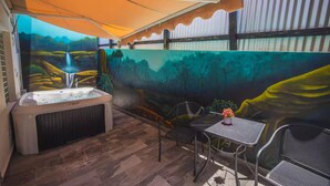 A hot tub with a waterfall mural, outdoor seating, and a covered patio area. - Chris Home for 20 Guests - Private Pool & Jacuzzi (Ensenada)